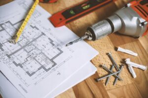 Construction blueprints and moisture testing tools laid out for an ESG pre-drywall inspection in North Carolina
