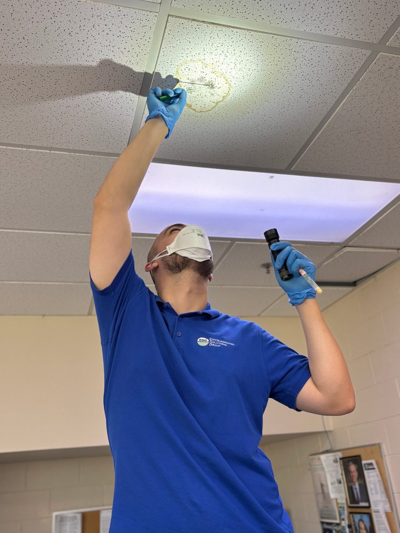 ESG inspector examining a ceiling for moisture and mold during an assessment in Greensboro, NC