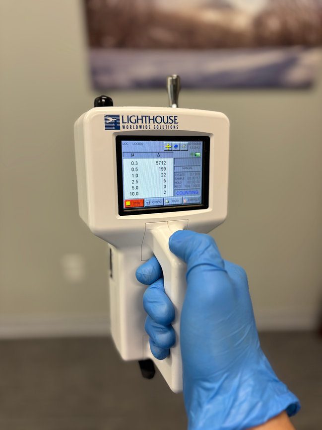Handheld environmental meter displaying recorded air quality readings